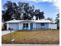 Cute newly renovated home with light blue exterior, white trim, and a well-manicured lawn at 7534 Birchwood Dr, Port Richey, FL 34668