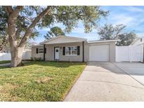 Newly renovated home with a landscaped yard and driveway at 9240 Whitman Ln, Port Richey, FL 34668