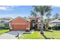 Charming single-story home with a well-manicured lawn, mature landscaping, and a two-car garage at 1025 Ketzal Dr, Trinity, FL 34655