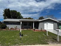 Charming single-story home featuring a well-manicured lawn and fresh exterior paint at 7207 Nova Scotia Dr, Port Richey, FL 34668