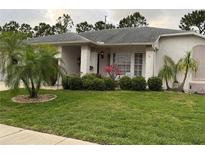 Charming single story home featuring a well-maintained lawn and attractive landscaping at 8111 Merrimac Dr, Port Richey, FL 34668