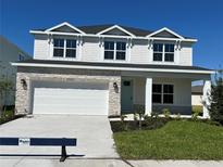 Charming two-story home featuring stone accents, a two-car garage, and a well-manicured lawn at 10126 Zennia Ln, Parrish, FL 34219