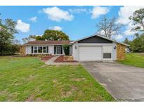 Charming single-story home with a well-manicured lawn, stone accents and attached two car garage at 10200 Sunburst Ct, Spring Hill, FL 34608