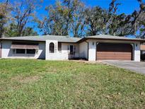 Charming single-story home featuring a stucco exterior, attached garage, and well-maintained front yard at 12501 Shadow Ridge Blvd, Hudson, FL 34669