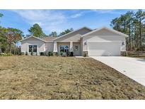 Charming single-story home featuring a neutral color scheme and attached two-car garage at 16434 Medley Rd, Weeki Wachee, FL 34614