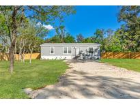 Charming single-story home featuring a well-maintained lawn and a gravel driveway on a sunny day at 3323 Parlow Ave, Spring Hill, FL 34606