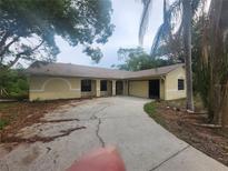 Charming single-story home with a spacious front yard and an attached two-car garage at 9179 Gillmar St, Spring Hill, FL 34608