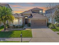 Beautiful single-Gathering home featuring a well-manicured lawn, two-car garage, and a cozy front porch at 12824 Tikal Way, Trinity, FL 34655