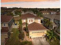 Beautiful two-story home featuring a manicured lawn, brick walkway, and attached two-car garage at 18819 Sunterra Dr, Land O Lakes, FL 34638
