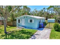 Charming single-story home featuring a well-manicured lawn, white-trimmed windows, and a cozy front entrance at 1888 Douglas Ave, Dunedin, FL 34698