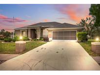 Charming single-story home features a well-manicured lawn, screened garage, and long driveway at 6112 Kinlock Ave, Spring Hill, FL 34608