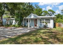 Charming single-story home with a red front door, stone pillars, and lush landscaping at 1101 N Betty Ln, Clearwater, FL 33755
