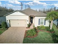 Charming single-story home with a well-maintained front yard, brick driveway, and attached two-car garage at 18629 Coastal Shore Ter, Land O Lakes, FL 34638