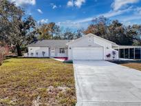 Charming single-story home features an attached two-car garage and long driveway at 12242 Greenwood St, Brooksville, FL 34613