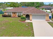 Charming single-story home featuring a stone accent wall, arched entryway, and a well-maintained lawn at 2013 Meredith Dr, Spring Hill, FL 34608
