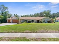 Charming single-story home with manicured lawn, stone accents, and a welcoming front entrance at 4603 Lake In The Woods Dr, Spring Hill, FL 34607