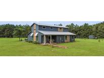 Charming two-story home with a metal roof and a large, well-maintained yard at 11151 Lu Wista Ln, Brooksville, FL 34601