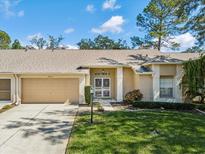 Charming single-story home featuring a well-manicured lawn, attached garage, and inviting front entrance at 18325 Whitacre Cir, Hudson, FL 34667