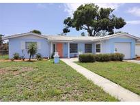 Charming, light blue single-story home with well-manicured lawn and inviting pathway to the front door at 5830 34Th N Ave, St Petersburg, FL 33710