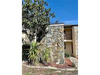 Two-story condo building featuring a stone facade and well-maintained landscaping at 7109 Kirsch Ct # 2, New Port Richey, FL 34653