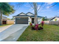 Charming single-Gathering home boasts a well-manicured lawn and a two-car garage at 12706 N Ola Ave, Tampa, FL 33612