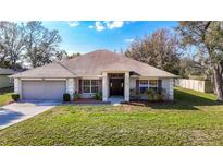 Charming single-story home with manicured lawn, two-car garage, and neutral color palette at 469 Fairbanks Rd, Spring Hill, FL 34608