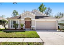 Charming single-story home featuring well-manicured landscaping, a two-car garage, and a welcoming front entrance at 5903 War Admiral Dr, Wesley Chapel, FL 33544