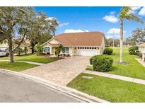 Charming one story home with a brick paver driveway and a well manicured lawn with shade trees at 6741 Northlake Dr, Zephyrhills, FL 33542