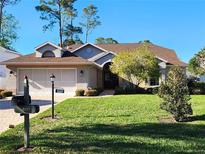 Charming single-story home with lush green lawn and mature landscaping at 8157 Hidden Hills Dr, Spring Hill, FL 34606