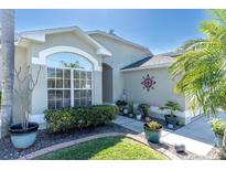 Charming home exterior with manicured landscaping, beautiful plants, and a decorative window at 11700 Leda Ln, New Port Richey, FL 34654