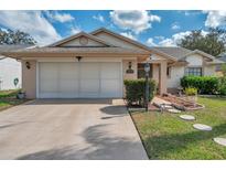 Charming single-story home with a well-maintained lawn and a two-car garage at 13032 Pinnacle Ln, Hudson, FL 34669
