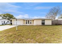 Charming single-story home with an attached garage and a well-maintained lawn in a residential neighborhood at 7610 Ilex Dr, Port Richey, FL 34668