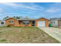 Charming single-story home features an attached garage and a well-maintained front yard at 10736 Queens Rd, Port Richey, FL 34668