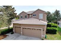 Two story home featuring an attached two car garage, neutral color scheme, and well maintained landscaping at 13304 Mandalay Pl, Spring Hill, FL 34609