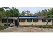 Single story home with metal roof, trimmed windows, and mature landscaping at 17932 Wendy Sue Ave, Hudson, FL 34667