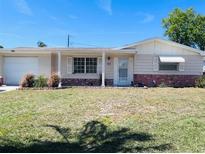 Charming single-story home with a well-maintained lawn and tidy landscaping at 3243 Bayport Dr, Holiday, FL 34691