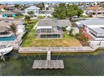 Aerial view of a backyard with a pool enclosed in a screened-in lanai and a dock extending into the water at 3328 Gulfview Dr, Hernando Beach, FL 34607