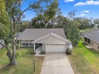 Charming single-story home with a well-manicured lawn and attached two-car garage at 8002 Sugarbush Dr, Spring Hill, FL 34606