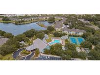 Overhead view of community amenities including pool, tennis courts, and lakefront property, surrounded by lush trees at 19325 Water Oak Dr # 205, Port Charlotte, FL 33948