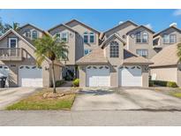 Townhouse exterior showcasing multi-car garages, stucco facades, manicured landscaping and architectural design at 2764 Countryside Blvd # 3, Clearwater, FL 33761
