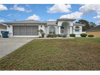 Charming single-story home featuring a two-car garage, arched entryway, and well-maintained lawn at 3024 Dumas Ave, Spring Hill, FL 34609