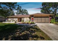 Charming single-story home featuring well-maintained landscaping and an attached two-car garage at 3273 Bluestone Ave, Spring Hill, FL 34609