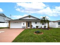 Charming single-story home featuring a well-maintained lawn, attached garage and stone accented entrance at 4048 Orient Dr, Hernando Beach, FL 34607