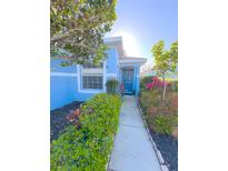 Charming home exterior with a well-maintained front yard, blue paint, and inviting walkway to the front door at 2931 Walnut Grove Ct, Holiday, FL 34691