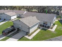 Aerial view of a well-maintained home with a two-car garage, neat landscaping, and an expansive roof at 3806 River Oaks Ct, New Port Richey, FL 34655