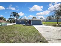 Charming single-story home featuring a well-manicured lawn and beautiful landscaping at 4206 Candler Ave, Spring Hill, FL 34609
