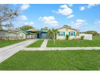 Exterior shot of charming home with a spacious lawn, driveway, and colorful accents at 4544 Cynthia Ln, Spring Hill, FL 34606