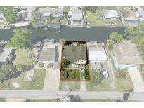 Aerial view of waterfront home with boat dock, lush landscaping, and a quaint outdoor area at 5319 Ray Dr, Weeki Wachee, FL 34607