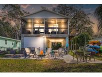 Inviting two-story home with a garage, screened porch, patio, and outdoor seating around a fire pit at 6183 Waverly Rd, Weeki Wachee, FL 34607