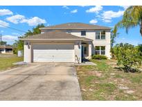 Inviting two-story home with a spacious two-car garage and lush landscaping at 9291 Geranium Ave, Spring Hill, FL 34606